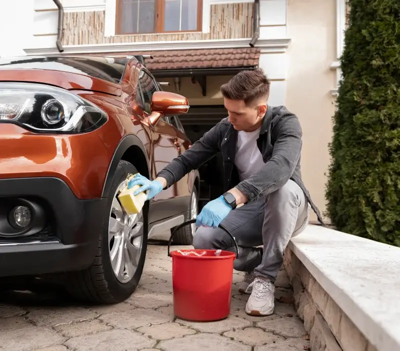 Lavage auto à domicile Dambelin : professionnel intervenant sur un véhicule